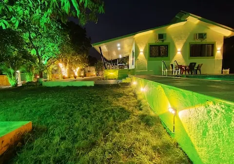 Villa exterior aglow in the evening at PN Nature's Paradise Villa, Igatpuri