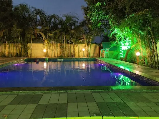 Private swimming pool lit at night at PN Nature's Paradise Villa, Igatpuri